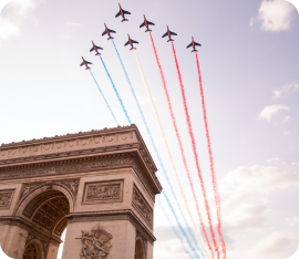 Avions de la patrouille de France volent au dessus de l'Arc de Triomphe dans un panache de fumée tricolore