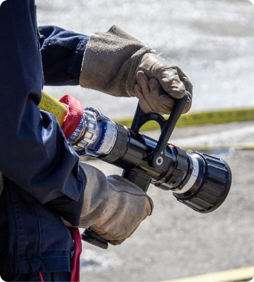 Un pompier volontaire s'entraine au maniement de la lance à incendie